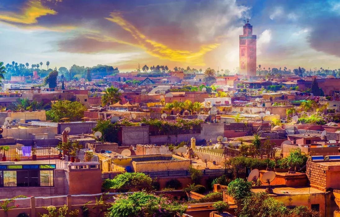 Les toits de Marrakech et le minaret de la Koutoubia sous un ciel de fin de journée